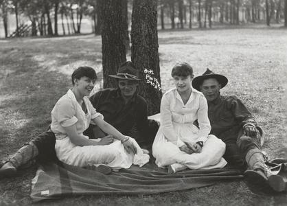 Four people under a tree at Camp Douglas