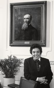 Donna Shalala posing in front of Chancellor John Bascom's portrait
