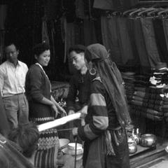 Hmong woman discusses purchase with shop proprietor