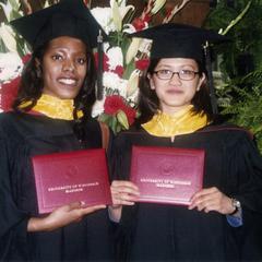 Two graduates and diplomas at 2002 graduation