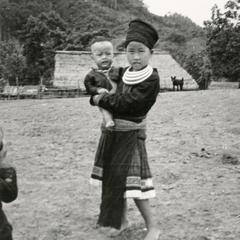 A Blue Hmong (Hmong Njua) girl holds her little brother in a Hmong village in the vicinity of Muang Vang Vieng in Vientiane Province