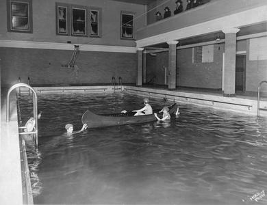 Swimmers in pool with canoe