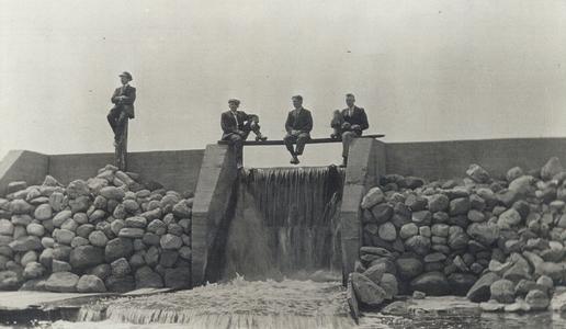 Four Men sitting on the dam