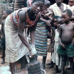 Sifting Cassava Flour in Woven Urn