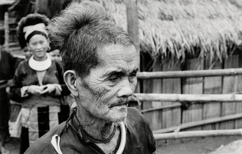 An elderly Blue Hmong (Hmong Njua) man stands in a Hmong village in the vicinity of Muang Vang Vieng in Vientiane province