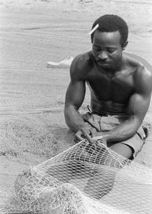 Man Mending Net for Ocean Fishing