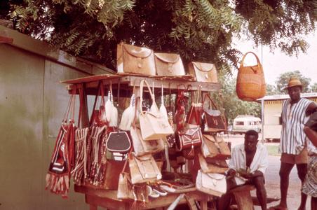 Vendor in Bolgatanga Displays Leather Handbags for Sale