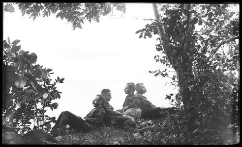 Group reclining under a tree, "Worrying about business"