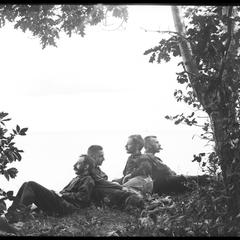 Group reclining under a tree, "Worrying about business"