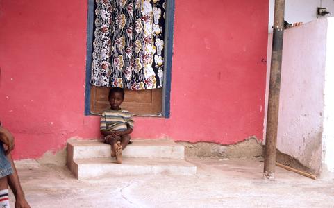 Child sitting in front of house