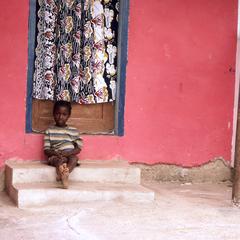 Child sitting in front of house