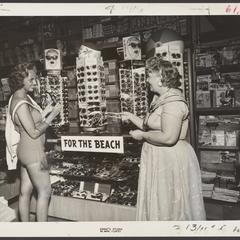A saleswoman helps a customer select sunglasses