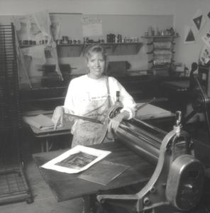 Student working with an engraving press