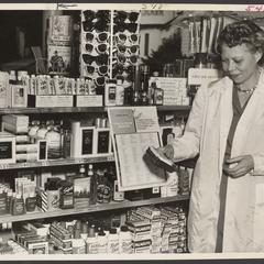A salesclerk examines items from a checklist of vacation needs