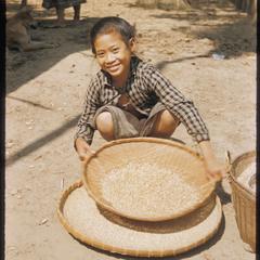 Girl winnowing rice