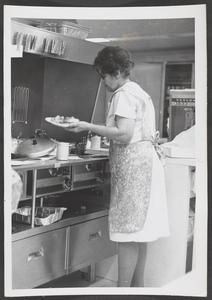 Cafeteria worker serving up a plate of food