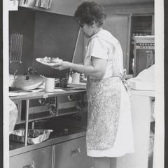 Cafeteria worker serving up a plate of food