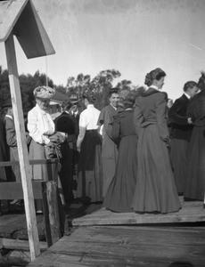 Men and women standing on boardwalk
