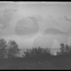 Clouds over lake with willows