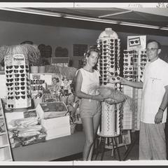 A pharmacist helps a young woman select summer merchandise