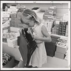 A young girl examines school supplies from a drugstore display