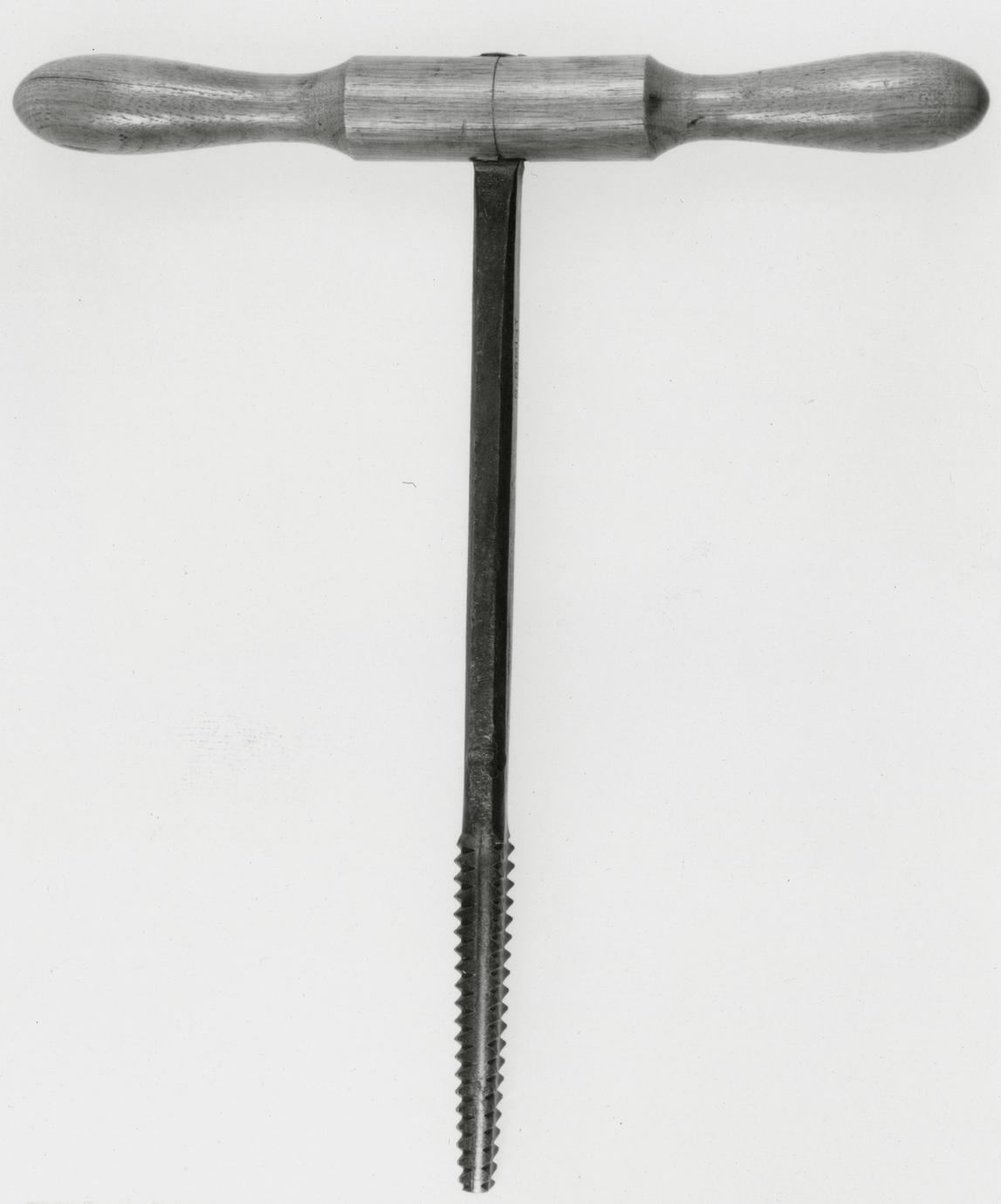 Black and white photograph of a metal screw tap.