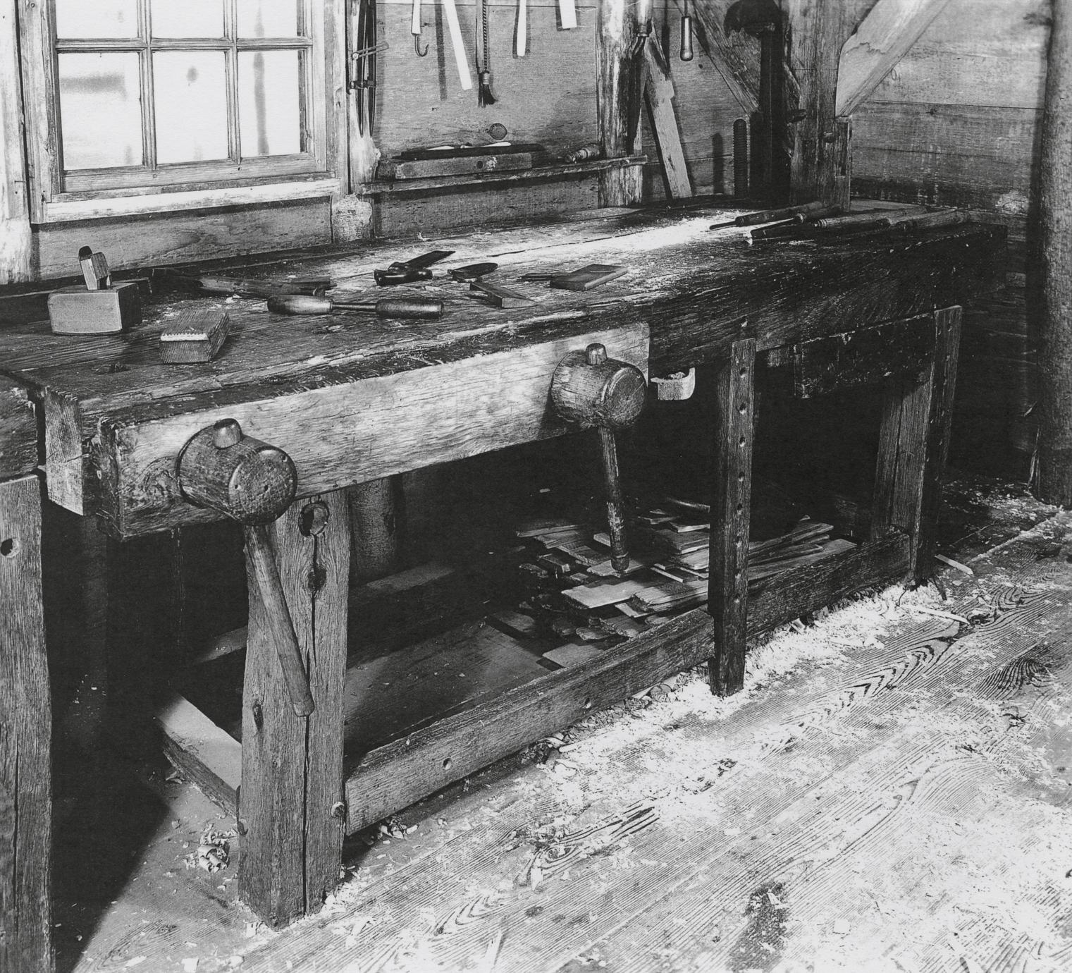 Black and white image of a workbench in a shop.