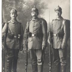 [Group portrait of three soldiers holding rifles with bayonets affixed]