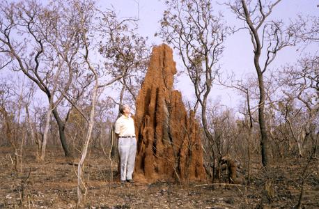 Man next to termite mound
