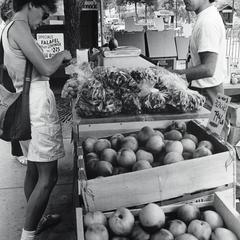 Woman buying fruit from vendor