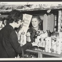 A woman receives help at a cosmetics counter