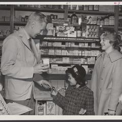 A pharmacist assists two shoppers