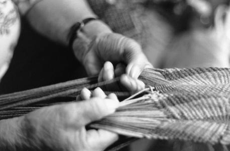 Adeline Wanatee fingerweaving a yarn sash