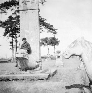 A foreign military officer sitting on a stone monument.