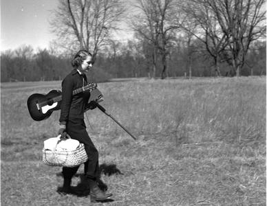 Nina Leopold with picnic basket, guitar, books, and shotgun