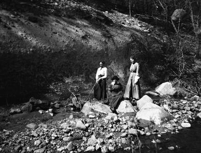 Three women in creek bed at Frijoles Canyon