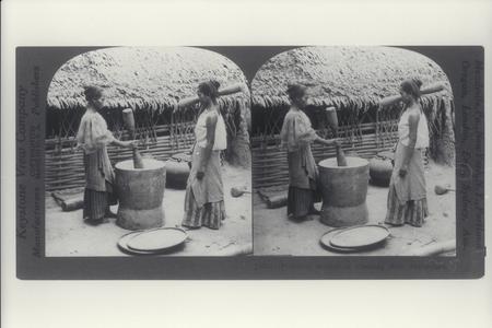 Two Filipino women pounding rice, ca. 1900