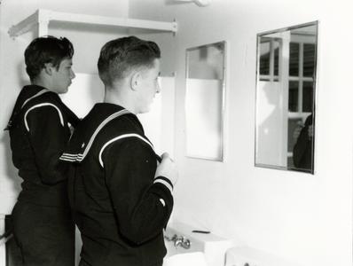 Coast Guard men in front of mirrors