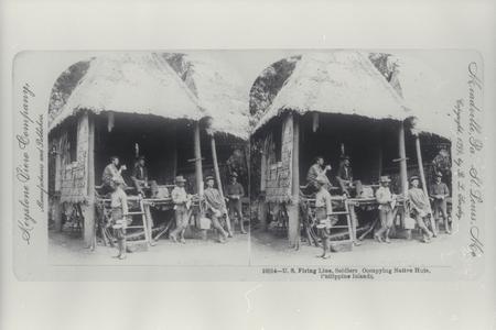 U.S. soldiers relax in a thatched hut, 1899