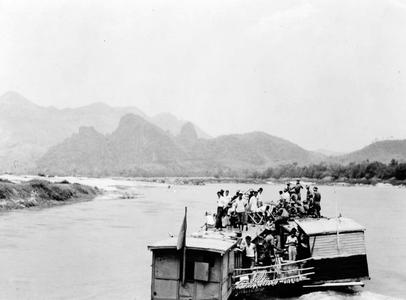 Barges linked together on Mekong traveling upstream to Pak Ou