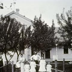 Family poses in front of rural home