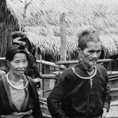 An elderly Blue Hmong (Hmong Njua) husband and wife walk along a path in a Hmong village in the vicinity of Muang Vang Vieng in Vientiane Province