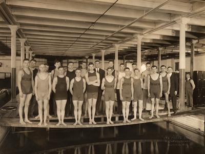 Men's swim team posed on planks over the Armory Tank