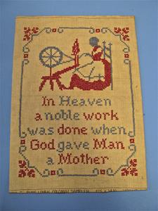 "In heaven" cross-stitched sampler in blue and red