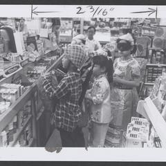 Costumed children stand by a drugstore counter with trick or treat bags