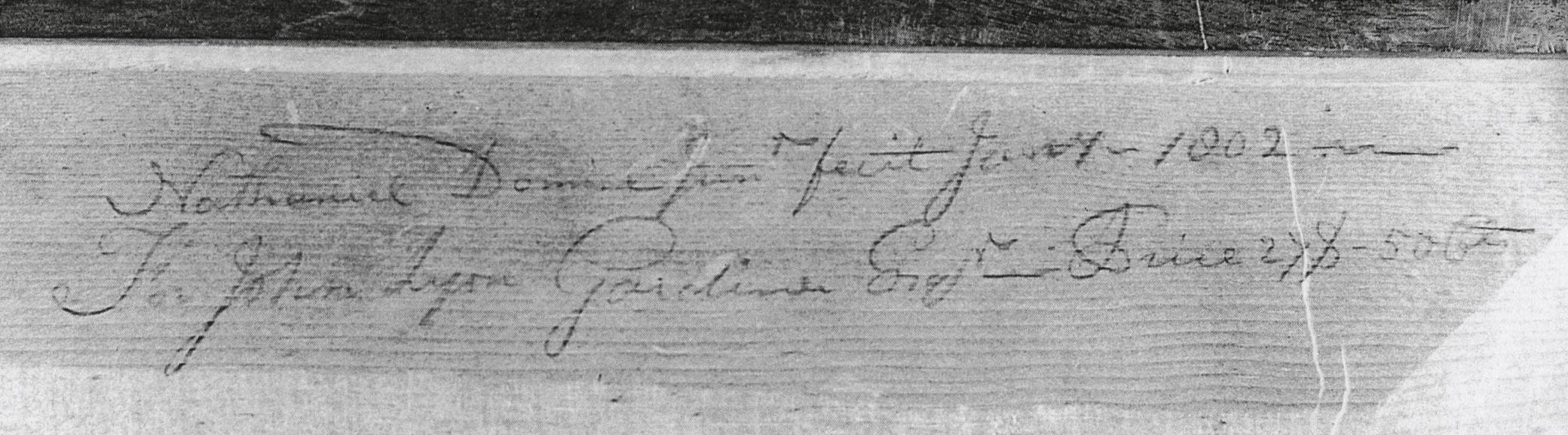 Black and white photograph of an inscription on a desk.