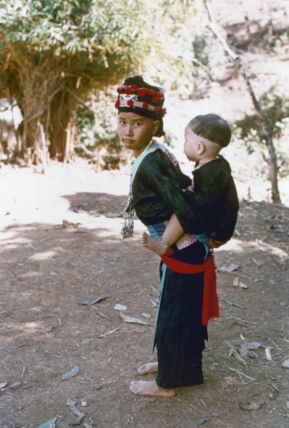 Hmong girl carrying her little brother on her back in Houa Khong Province