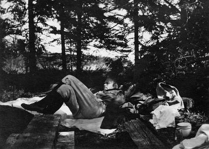 Carl Leopold, Jr. reclining at campsite at Les Cheneaux