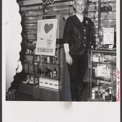 A salesclerk stands at a cosmetics counter