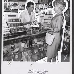 A cosmetics clerk presents a product to a customer